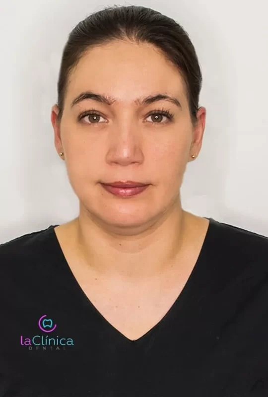 Mujer con camiseta negra, especialista en cirugía maxilofacial, foto profesional con logo de La Clínica Dental.
