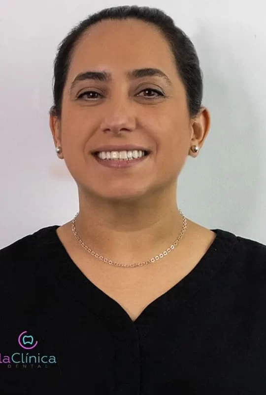Dentista sonriente en uniforme negro, representando a La Clínica Dental, especializada en cirugía maxilofacial.