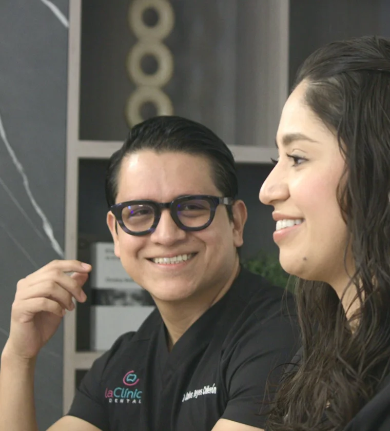 Dentista sonriendo y paciente conversando en La Clinica Dental Lindavista CDMX, destacando la atenci&oacute;n personalizada y la comodidad del consultorio.