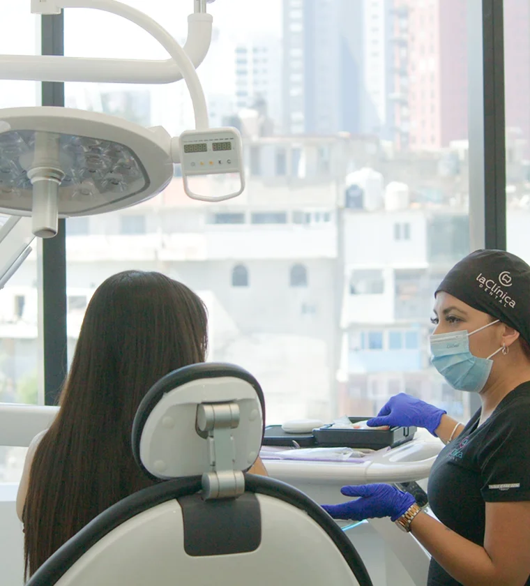 Consulta dental en La Clinica Dental Lindavista CDMX, con dentista explicando tratamiento a paciente en un ambiente moderno y luminoso.